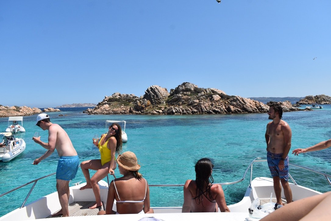 Friends on a boat over turquoise water.