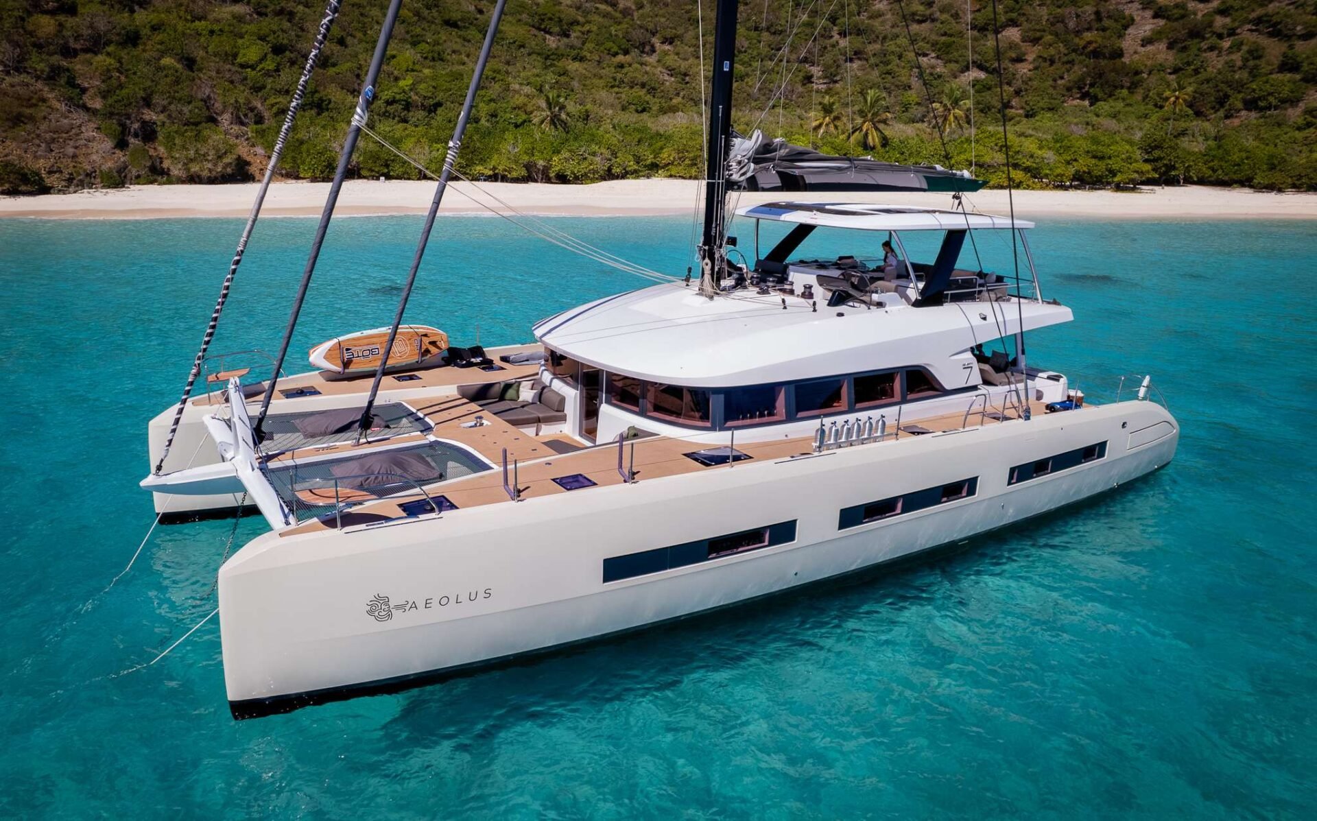 A sleek white catamaran on clear Caribbean water.