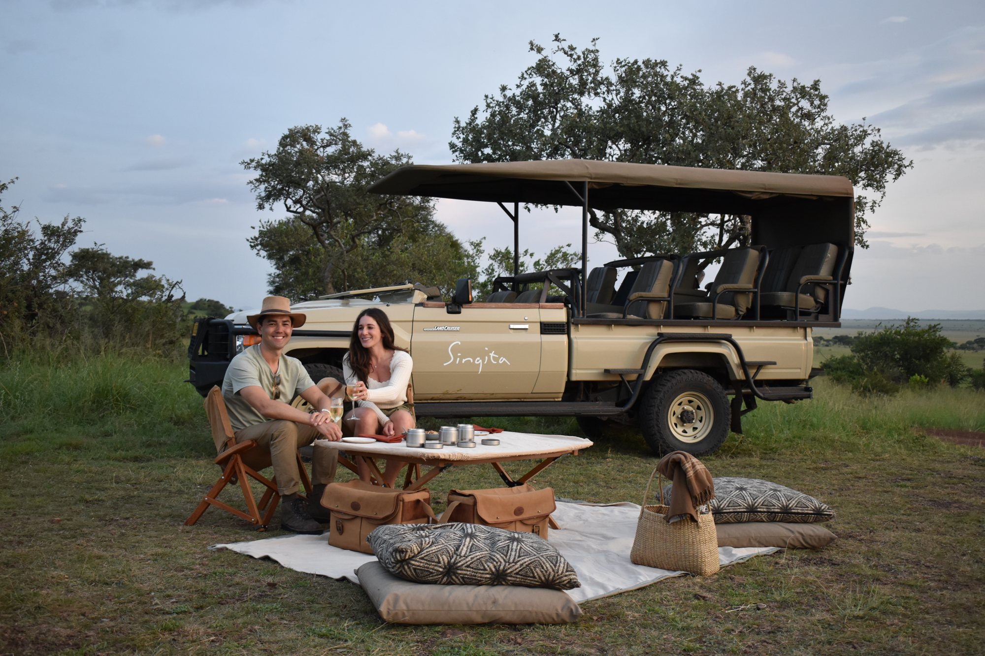 A safari picnic beside the game vehicle.