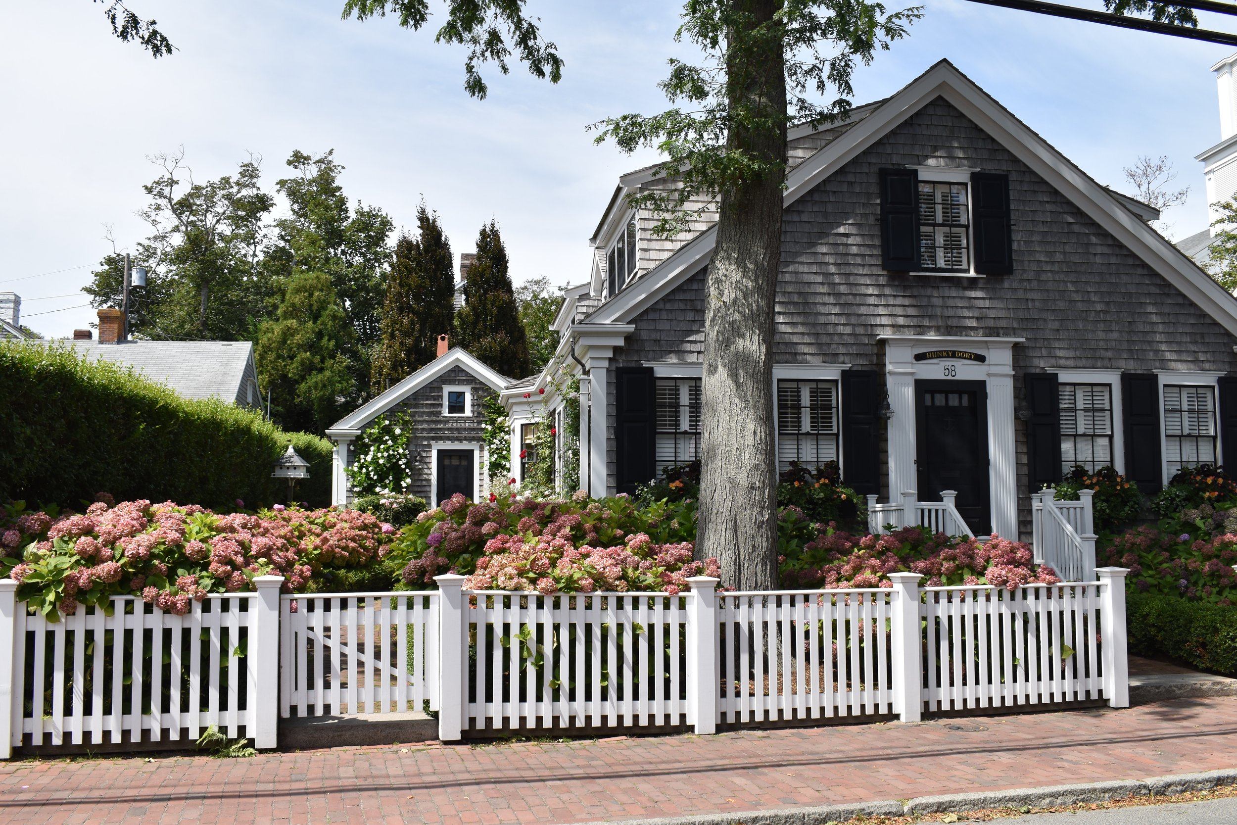 A house with gray wooden shingles and black trim.