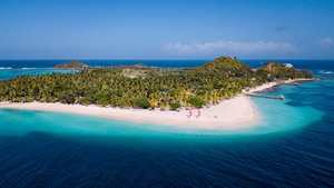 A small private island fringed by sand in the Grenadines.