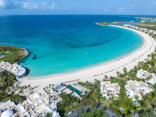 A white-sand crescent beach lined with villas.