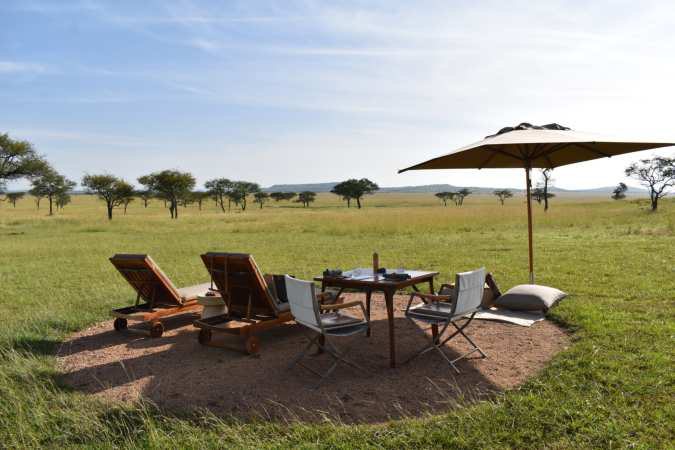 Loungers and a shaded table on the savannah.